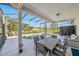 Covered outdoor patio with a dining table overlooking the screened-in pool at 5239 Los Palma Vista Dr, Orlando, FL 32837