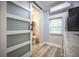 View of kitchen and bathroom area with sliding frosted glass door, wood look flooring, and stainless fridge at 524 W Winter Park St, Orlando, FL 32804