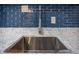 Close up of stainless steel sink with modern faucet, white countertop, and blue tiled backsplash at 524 W Winter Park St, Orlando, FL 32804