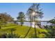 Lush backyard with mature trees leads to a serene lake with a private dock and boat lift at 535 Spring Club Dr, Altamonte Springs, FL 32714