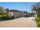 Three-car garage with paver driveway and verdant landscaping overlooking the lake at 535 Spring Club Dr, Altamonte Springs, FL 32714