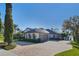 Beautiful home featuring a large paver driveway, three-car garage, and mature landscaping at 535 Spring Club Dr, Altamonte Springs, FL 32714