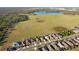 Scenic aerial view of residential houses next to a large green field and lake, showcasing the community's location at 5571 Sycamore Canyon Dr, Kissimmee, FL 34758