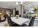 Bright dining room features a modern white table, stylish seating, and sliding glass doors to the outdoor space at 5571 Sycamore Canyon Dr, Kissimmee, FL 34758