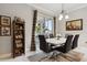 Elegant dining room featuring a modern table, stylish chairs, and sliding glass doors leading to the outdoors at 5571 Sycamore Canyon Dr, Kissimmee, FL 34758