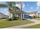 Inviting single-story home with a manicured lawn, palm trees, and covered porch, perfect for curb appeal at 5571 Sycamore Canyon Dr, Kissimmee, FL 34758