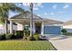 Single-story home with covered porch, neat lawn, palm trees, and an attached two-car garage at 5571 Sycamore Canyon Dr, Kissimmee, FL 34758