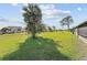 A expansive, green backyard featuring mature trees and lush green grass at 56 Pine Island Cir, Kissimmee, FL 34743