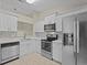 Contemporary kitchen with stainless appliances and updated white cabinets at 56 Pine Island Cir, Kissimmee, FL 34743