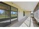 A screened patio area features concrete floors and sliding glass doors into the home at 56 Pine Island Cir, Kissimmee, FL 34743