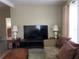 Comfortable living room with a large TV, sofa, and decorative lamps at 6023 Sage Dr, Orlando, FL 32807