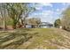 Expansive backyard view highlighting the home's exterior, mature trees and partially fenced yard at 655 W Date St, Lake Wales, FL 33859