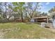 Spacious backyard showcasing lush greenery, a covered patio and an external generator at 655 W Date St, Lake Wales, FL 33859