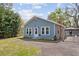 Charming blue home featuring white trim, an American flag, and well-maintained landscaping at 655 W Date St, Lake Wales, FL 33859