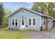 Charming blue home featuring white trim, an American flag, and well-maintained landscaping at 655 W Date St, Lake Wales, FL 33859