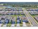 An aerial view of a neighborhood with sidewalks and retention ponds surrounded by lush forest in the background at 659 Daring Dr, Davenport, FL 33837