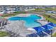 An aerial shot of the community pool that features multiple covered seating areas, lots of chairs, and palm trees at 659 Daring Dr, Davenport, FL 33837