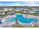 An aerial shot of the community pool featuring a playground, covered seating, chairs, and palm trees at 659 Daring Dr, Davenport, FL 33837