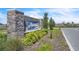 The community sign is beautifully landscaped with plants, a stone base, and modern lettering that says Astoria at 659 Daring Dr, Davenport, FL 33837