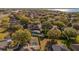 An aerial view shows the backyard pool and lanai, as well as a neighborhood with mature trees and water in the distance at 729 Strihal Loop, Oakland, FL 34787