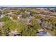 An aerial view captures a community surrounded by lush greenery, a nearby highway, and a cityscape on the horizon at 729 Strihal Loop, Oakland, FL 34787