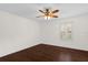 Bright bedroom featuring dark hardwood flooring, a ceiling fan, a window with white shutters, and ample natural light at 729 Strihal Loop, Oakland, FL 34787