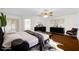 Staged bedroom with modern furniture, wood floors, and a ceiling fan at 729 Strihal Loop, Oakland, FL 34787