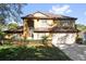 Charming two-story home featuring a well-manicured lawn and an attached two-car garage at 729 Strihal Loop, Oakland, FL 34787