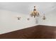 Expansive living room featuring dark wood floors, two chandeliers, and natural light at 729 Strihal Loop, Oakland, FL 34787