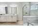 Bright bathroom with double sink vanity and granite counters alongside a tiled shower and soaking tub at 7717 Graben St, Kissimmee, FL 34747