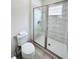 Bathroom featuring wood-look tile flooring, a toilet, and a tiled glass-enclosed shower at 7717 Graben St, Kissimmee, FL 34747