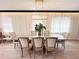 The dining area features modern chandelier and a dining table with seating for six highlighted by large bright windows at 7717 Graben St, Kissimmee, FL 34747