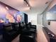 Home theater room featuring reclining seats, a large television screen, a popcorn mural, and dim lighting at 7717 Graben St, Kissimmee, FL 34747