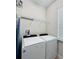 Functional laundry room with modern washer and dryer units, storage shelf, and natural light at 7717 Graben St, Kissimmee, FL 34747