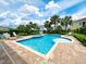 Beautiful community swimming pool and hot tub surrounded by palm trees, lounge chairs, and lush landscaping at 7717 Graben St, Kissimmee, FL 34747