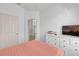 Bright bedroom featuring a white dresser, TV, and soft pink accents at 8136 Fan Palm Way, Kissimmee, FL 34747