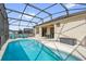 A screened in pool features multiple lounge chairs for sunbathing and an attached outdoor dining area at 8136 Fan Palm Way, Kissimmee, FL 34747