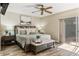 Cozy bedroom with wood-look flooring, a ceiling fan, and sliding glass doors to the pool at 8534 Black Mesa Dr, Orlando, FL 32829