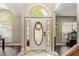 Bright foyer with an arched transom window and a decorative front door with custom glass at 8534 Black Mesa Dr, Orlando, FL 32829