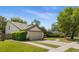 View of the home and the garage; the home features a pristine lawn and sidewalk at 8534 Black Mesa Dr, Orlando, FL 32829