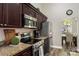 Close up of a well-equipped kitchen with stainless steel appliances and dark wood cabinetry at 8534 Black Mesa Dr, Orlando, FL 32829