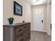 Bright entryway featuring a white front door, tiled floor, and a wooden dresser with decor at 8813 Tatara, Orlando, FL 32836