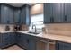 Kitchen featuring custom blue cabinetry, stainless steel appliances, and sleek countertops at 8929 Charleston Park # 12, Orlando, FL 32819