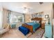 Stylish bedroom with a woven headboard bed, blue bedding, and patterned curtains at 936 N Baker St, Mount Dora, FL 32757