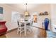 Bright dining area with white table and chairs, a woven light fixture, and decorative shelving at 936 N Baker St, Mount Dora, FL 32757