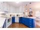 Bright kitchen with white cabinetry, appliances, and wooden floors at 936 N Baker St, Mount Dora, FL 32757