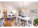 Open-concept living room and dining area with white sofa, blue accents, and a woven pendant light at 936 N Baker St, Mount Dora, FL 32757