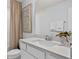 Clean bathroom with white vanity, neutral wall paper, large mirror and shower with curtain at 10246 Hadley St, Orlando, FL 32829