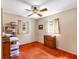 Bedroom with bright orange carpet, classic dresser, ceiling fan, and two bright windows at 11207 Roberson Rd, Winter Garden, FL 34787