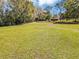 Expansive lot featuring lush green grass, mature trees, and a detached barn perfect for outdoor activities at 11207 Roberson Rd, Winter Garden, FL 34787